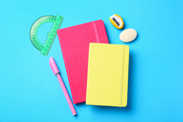 Pen and other stationery on light blue background, flat lay