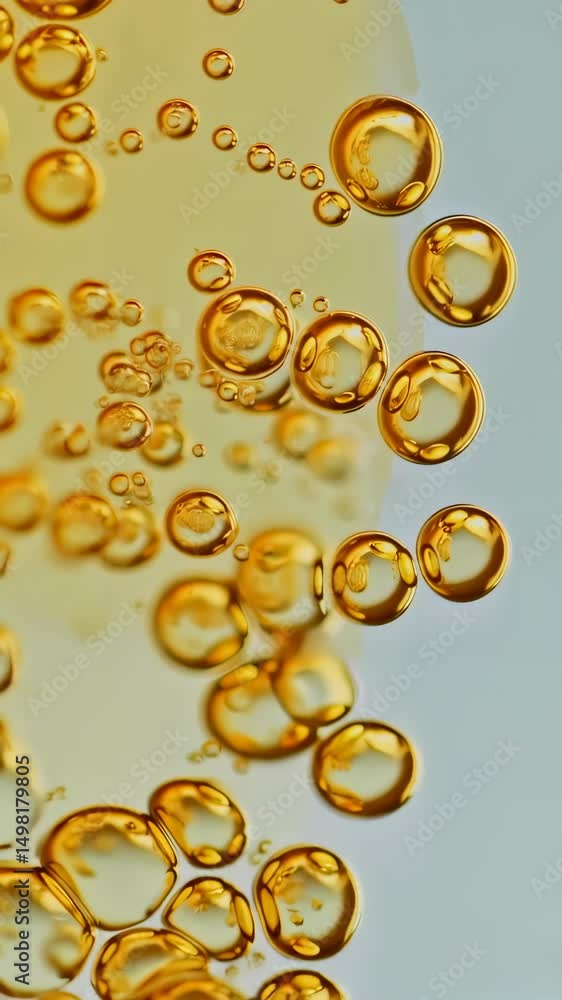 Poster golden bubbles float upwards on soft background. vertical format close view of abstract spheres.