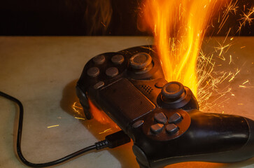 A burning gamepad with bright flashes of fire and sparks, symbolising overheating, malfunction or...