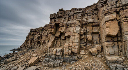 Rock formations on rugged coastal cliff landscape under dramatic cloudy sky