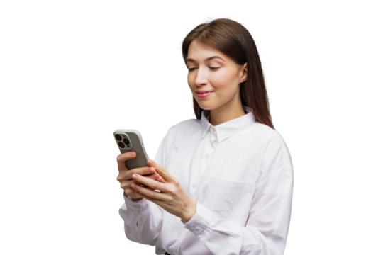 Woman in a white shirt engages with smartphone, smiling in a modern, bright setting