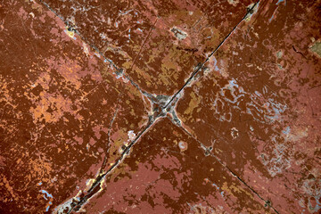brown surface covered with several layers of peeling multi-colored paint