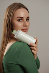 Model showcases beauty product in a modern studio setting during a commercial photoshoot