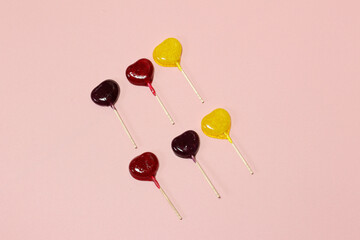 ピンク背景のカラフルな棒付きキャンディー