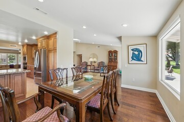 Modern dining room with wooden furniture and large windows.