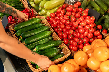 Fresh produce section with vegetables being arranged in a grocery store