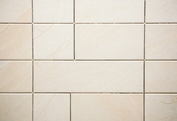 A close up of a white tiled wall in a bathroom.