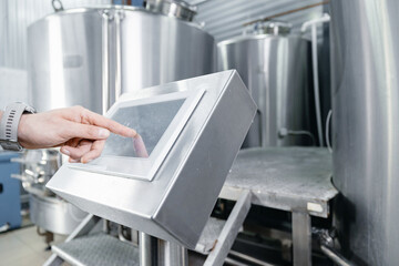 Beer production, Operator uses computer to check quality and temperature of yeast fermentation in...