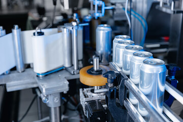 Automated beverage canning process in modern beer factory, blue light