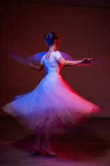 Fototapeta premium Caucasian woman dancing classical dance in tutu . Long exposure photo. 