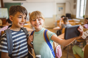 school girl and boy classmates take a self portrait in the classroom