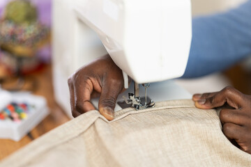Close up of man hands and sewing machine - process of making clothes