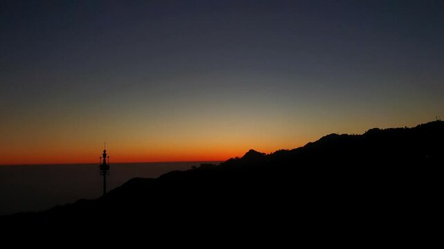 Mussoorie forest Uttarakhand winter lineis visible on the western horizon in the evening from midOctober to January. Sun sets, shades of yellow, red, orange, purple.