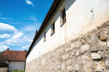 Historic stone wall with windows under blue sky