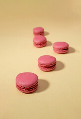 Colorful macaroons cakes on beige background. Flat lay.