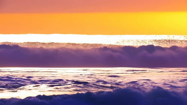 Ocean waves at sunset casting purple hues under a bright orange sky