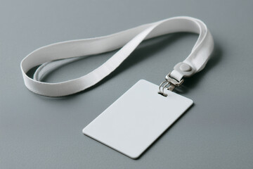 Empty ID card resting on a gray table, accompanied by a white lanyard, creating a clean and professional look for various events