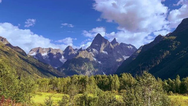 Teberdinsky Nature Reserve. View of Kosygin's glade in the Gonachkhir gorge and the top of Dombai-Ulgen mountain near Lake Tumanly-Kel on a sunny summer day. Panoramic landscape. Resort. 4K