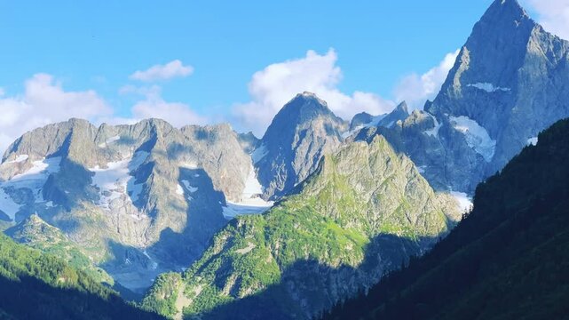 Teberdinsky Nature Reserve. View of Kosygin's glade in the Gonachkhir gorge and the top of Dombai-Ulgen mountain near Lake Tumanly-Kel on a sunny summer day. Panoramic landscape. Resort. 4K