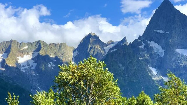Teberdinsky Nature Reserve. View of Kosygin's glade in the Gonachkhir gorge and the top of Dombai-Ulgen mountain near Lake Tumanly-Kel on a sunny summer day. Panoramic landscape. Resort. 4K