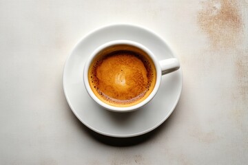 Obraz premium top view of a freshly brewed espresso in a white cup and saucer on a light textured surface