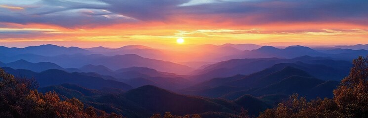 Obraz premium Sunset over a vast mountain range with layered ridges and colorful sky casting warm light and shadows on foliage in the foreground