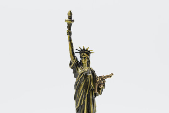 Miniatura de la estatua de la Libertad con una pistola en su mano izquierda, aislado en blanco