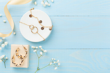 Elegant golden jewelry with decoration on wooden background, top view