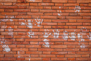 White powder handprints adorn the ancient brick city wall at Tha Phae Gate, Chiang Mai, a common...