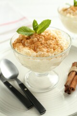 Delicious rice pudding with cinnamon and mint on table, closeup