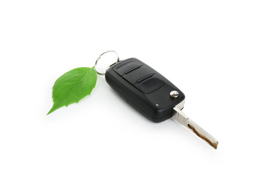 Fototapeta Car key and green leaf isolated on white. Save environment concept