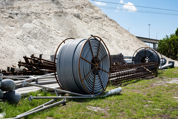 pre tied steel rebar at highway construction site and Coils of red polyethylene pipes for laying...