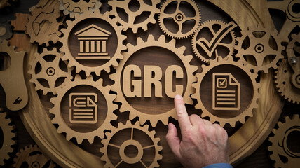Grc governance risk and compliance concept with gears and icons and a hand touching the center