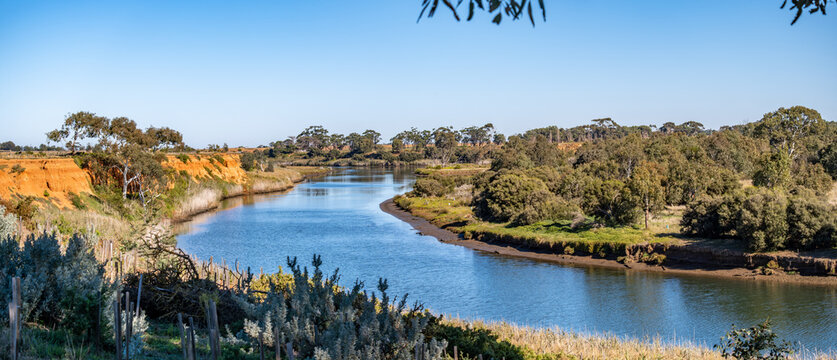 Fototapeta Panoramic view of the Werribee River in Werribee South, Australia, featuring winding waterways, cliffs, native vegetation, and a peaceful rural backdrop. Concept of ecology and natural erosion