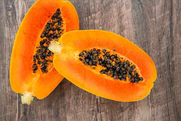 Papaya fruit on a dark wooden background. Slices of sweet papaya, Halved papayas
