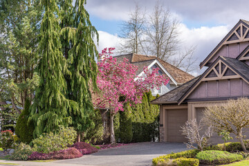 Two story stucco luxury house with nice spring blossom landscape in Vancouver, Canada, North America. Day time on May 2025.