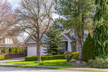 Two story stucco luxury house with nice spring blossom landscape in Vancouver, Canada, North America. Day time on May 2025.