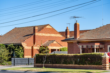 Traditional red brick Australian suburban houses with terracotta tile roofs. Classic residential...