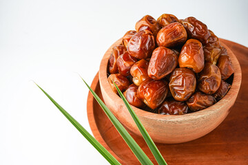 Dates fruit sukari or kurma sukari, in wooden bowl isolated on white background