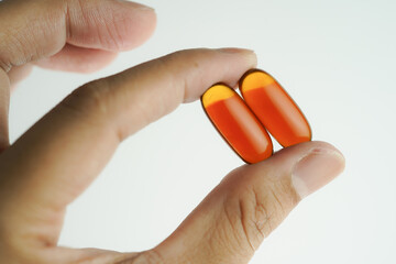Male hand holding Oil filled capsules, softgel of food supplements, fish oil, omega 3, vitamin E