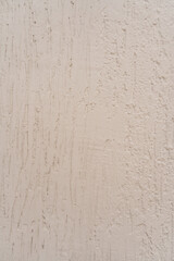 Superficie de pared estucada con textura mixta y acabado en tono beige claro 