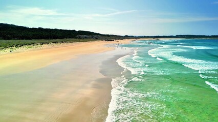A beautiful scenic beach view showcasing clear, inviting waves and soft, golden sand