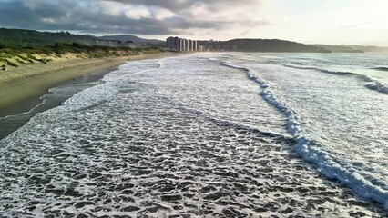 Experience the breathtaking coastal view featuring magnificent waves and a stunning sunset