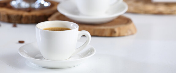 Cup of hot coffee on white table, closeup