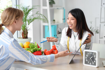 Female Asian nutritionist working with patient in office