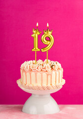 Pink birthday celebration cake with number 19 candle