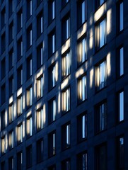 Modern Building Facade with Light Streaks on Windows at Dusk.