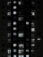 Obraz premium Apartment Building at Night Illuminated Windows and Balconies.