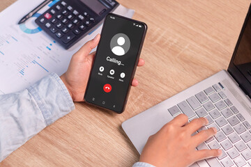 A business woman holding a mobile phone with outgoing call screen. Call someone with a voice call.