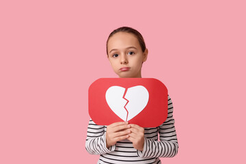 Upset little girl with heart dislike icon on pink background
